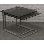 A retro chrome and glass pair of cantilever occasional tables.