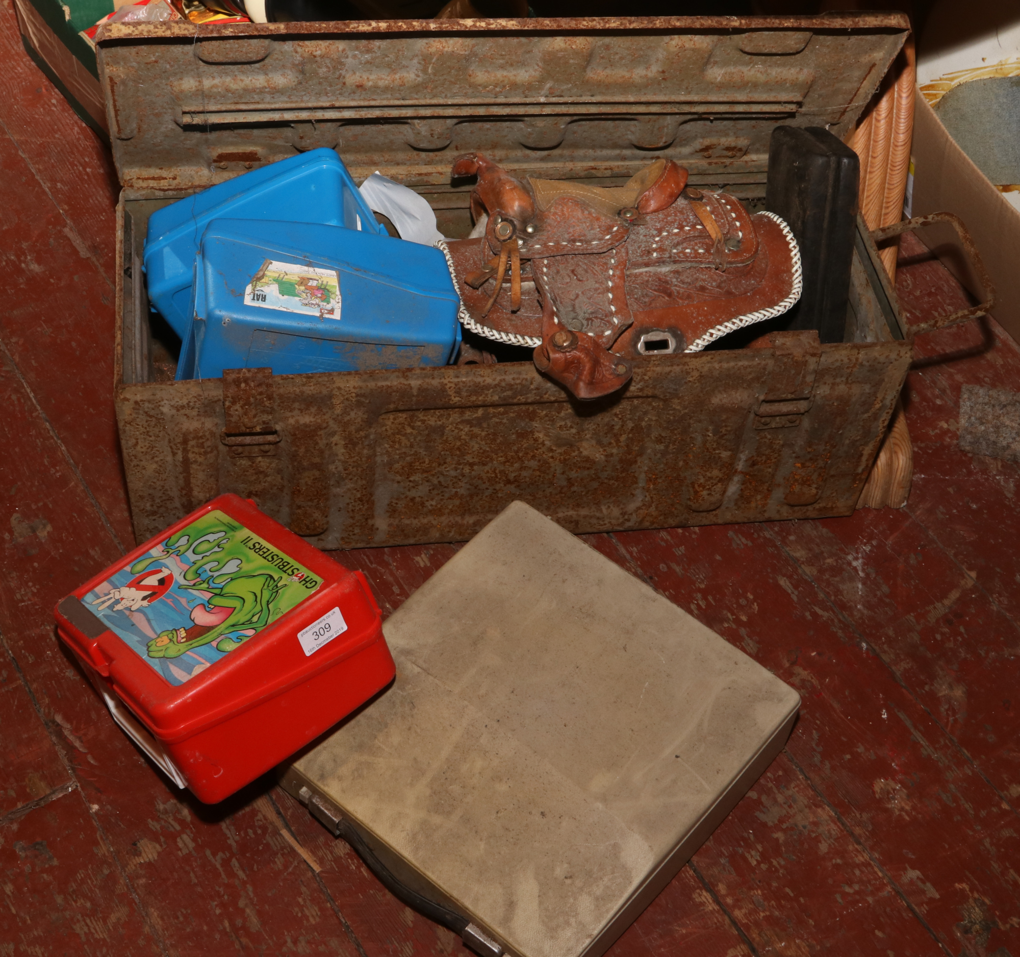 A military steel ammo box and contents of leather hand bag formed as a saddle, chisels, sharpening