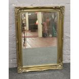An ornate gilt framed bevel edge wall mirror, 75cm x 30cm.