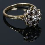 An 18ct gold and diamond snowflake cluster ring with chased border, 6.8 grams. Size R.