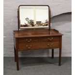 A George V figured mahogany dressing table with blind fret carving and raised on reeded square