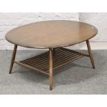 An Ercol coffee table with spindle under tier and raised on splay supports.