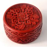 Red wood intricately carved circular box with oriental flower design. 6cm wide 3cm tall