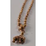 A 9ct gold necklace with a yellow metal` elephant charm pendant