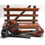 Wooden 6 pipe pipe stand with 1 ebonised pipe, burr walnut pipe and lion head design pipe