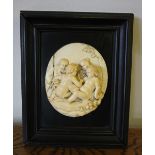 19th Century deeply carved ivory cameo - Bacchanalian putti, 12.5cm x 10.5cm x 2cm deep, in ebonised