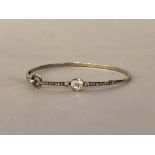 9ct white gold bangle formed from a 19th Century brooch, the white metal brooch element with face