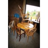 Elm table and a rocking chair, a rush seated chair and 4 elm seated stick back chairs