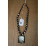 Mother of pearl pendant on black pearl necklace