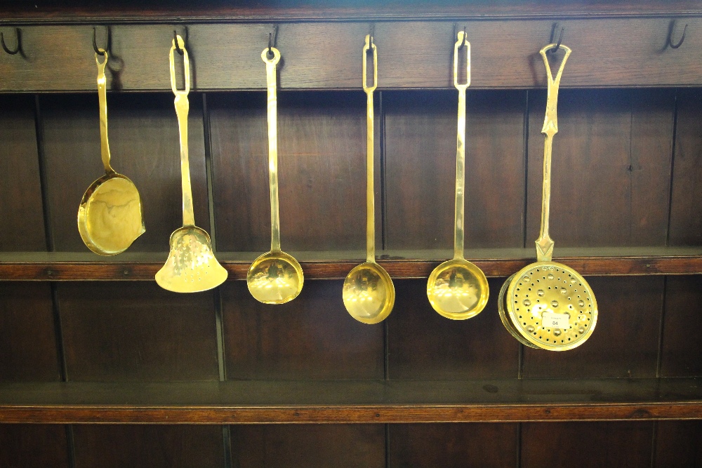 Early 19th Century brass circular chestnut roaster, cream skimmer, three ladles and a shallow pan