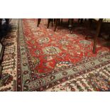 Large antique West Persian carpet, the field with palmettes on a red ground, within conforming