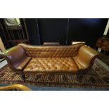 Early Victorian mahogany scroll arm three seat settee, upholstered in buttoned and studded brown