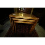 Nest of three glass topped teak tables