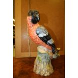 19th Century German porcelain model of a parrot, modelled on rustic stump, 33cm high, underglaze