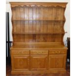 Reproduction light oak dresser with cupboard and drawers to base with plate rack decorated with