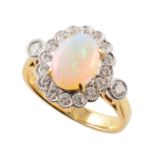 Opal and diamond oval cluster 18ct gold ring with diamond set shoulders , the oval cabochon cut opal