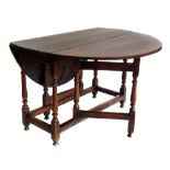 Mid 18th century oak gate-leg table, oval top with two leaves supported on baluster turned legs,