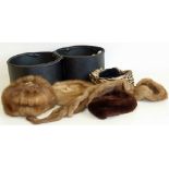 A collection of four fur hats and one fur stole contained within a faux leather travel hat box.