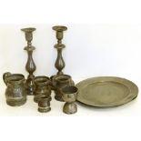 Two pewter plates, London touch marks to one, pair of candlesticks, egg cup and three measures.