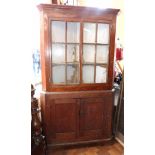 Georgian pine full length corner cupboard with glazed upper portion enclosing shaped shelves and