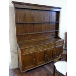 George III style oak dresser enclosing three drawers and four cupboards to base, two tier plate