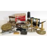 A box of metal items including brass candlesticks and laundry irons
