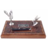 Desk stand with Rolls Royce and winged Bentley mascot on walnut base with two pens.