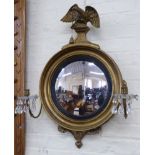 19th century style convex wall mirror with two candle sconces, surmounted by eagle, 17.5cm diameter.