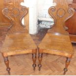 A pair of Victorian oak hall chairs on turned front legs Condition reports are not available for