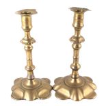 A pair of petal base brass candlesticks.