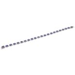 A silver sapphire bracelet, comprising twenty-two oval shape sapphires, with a push piece clasp,