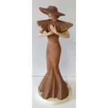 Art deco figureen of a young woman in dusky pink long dress, wide brimmed hat 29cm tall, stamp to