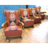 A set of four early 20th century fireside chairs with carved side panels depicting medieval interior