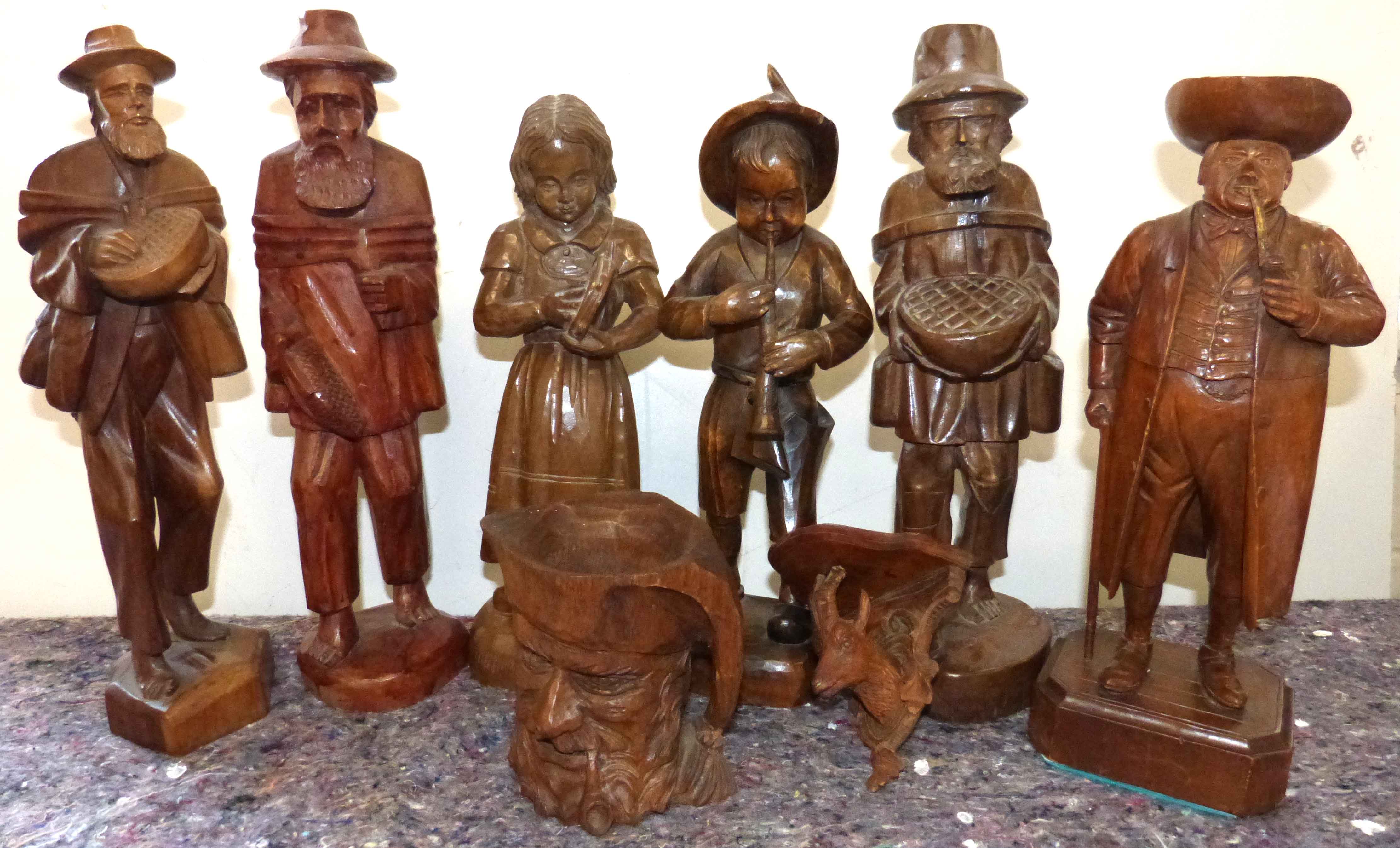 Six carved continental style figure, one being a tobacco jar, carved character style mug and