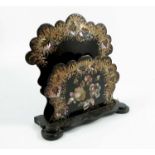 A 19th century black papier mache letter rack, the shaped rack decorated in gilt and inlaid mother