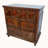 An antique oak chest of drawers, having three graduated drawers with decorative fielded panelled