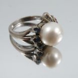 A cultured pearl ring, unmarked white mount, the 11mm diameter pearl with ruby and sapphire set