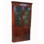 A 19th century mahogany floor standing corner cupboard, with two glazed doors to the upper