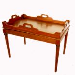 A mahogany butlers tray, with shaped edge, raised on a mahogany stand with ring tuned legs, 34ins