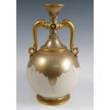 A Royal Worcester gilded ivory vase, decorated in the Persian style with a pair of gilt handles,