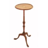 A mahogany tripod table, the circular top with inlaid decoration, raised on a slender turned