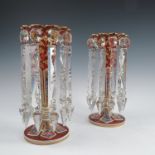 A pair of 19th century Bohemian lustres, having cranberry ground decorated with panels and gilt