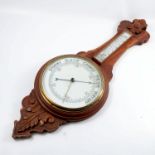 An oak banjo barometer, indistinctly signed, with mercury filled thermometer and carved