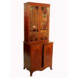 A mahogany two door cabinet, with glazed upper section, the base with inlaid panels to the doors,