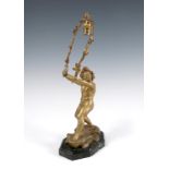 A French gilt metal lamp base, modelled as a semi naked boy holding a leaf hoop, on a rocky base