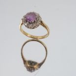 An amethyst and diamond 18 carat gold cluster ring, the round cut amethyst enclosed by ten single