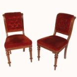 A set of six Victorian oak framed dining chairs, with button back and stuff over seat, raised on