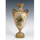 A Royal Worcester blush ivory vase, the two handled vase decorated with thistles and flowers, on a