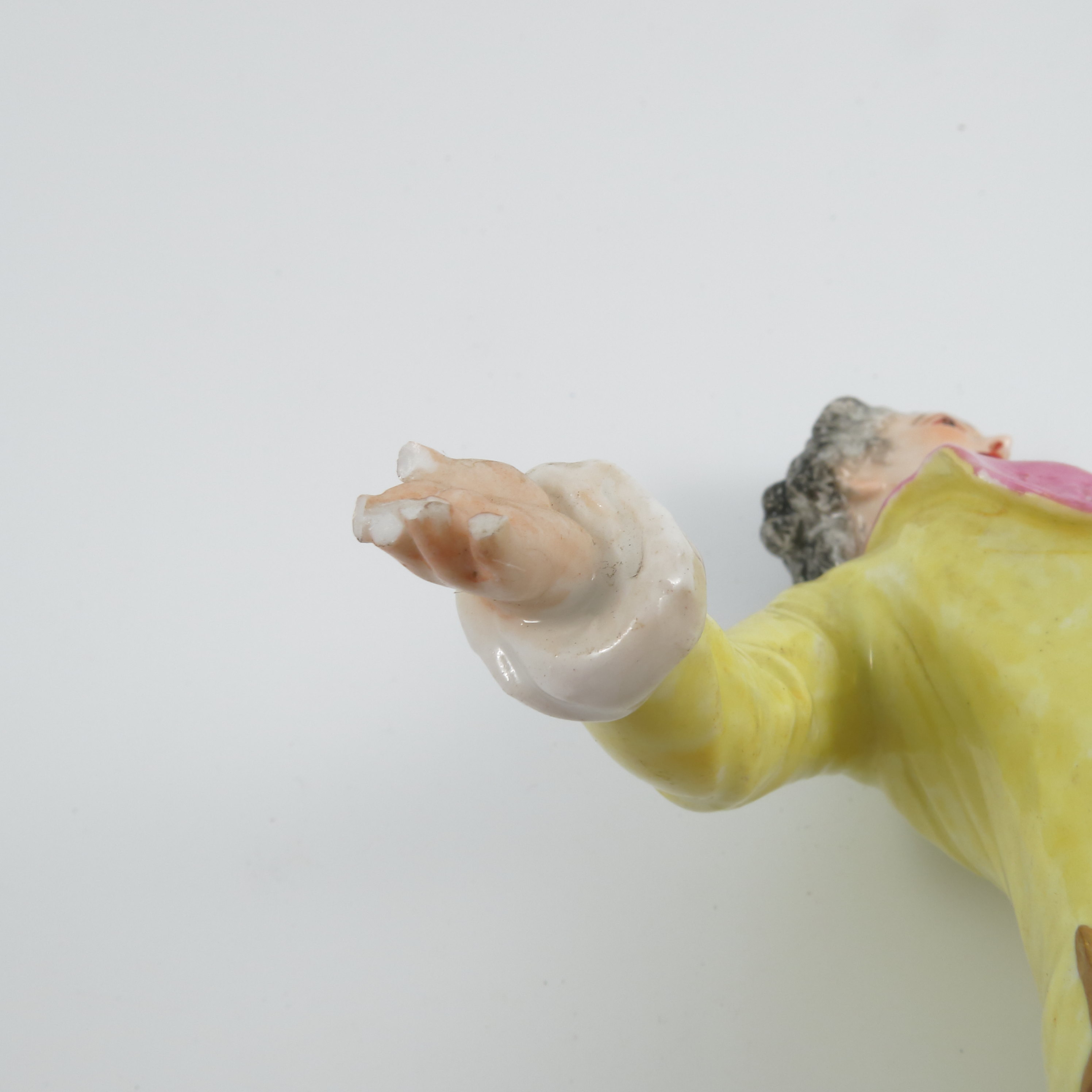 A pair of late 19th century continental porcelain figures, of a man wearing a yellow jacket and a - Image 6 of 9