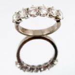 A six stone diamond half hoop ring, the white mount stamped '18ct', the uniform brilliant cuts
